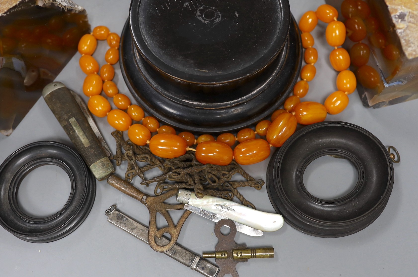 Mixed collectables including a pair of agate bookends, a mother of pearl handled silver fruit knife, faux amber necklace, hardwood stands etc.
